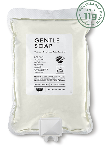 Een zakje milde zeep met een etiket waarop de ingrediënten en gebruiksaanwijzing staan vermeld, voorzien van een recyclingsymbool en een doseertuit aan de onderkant.