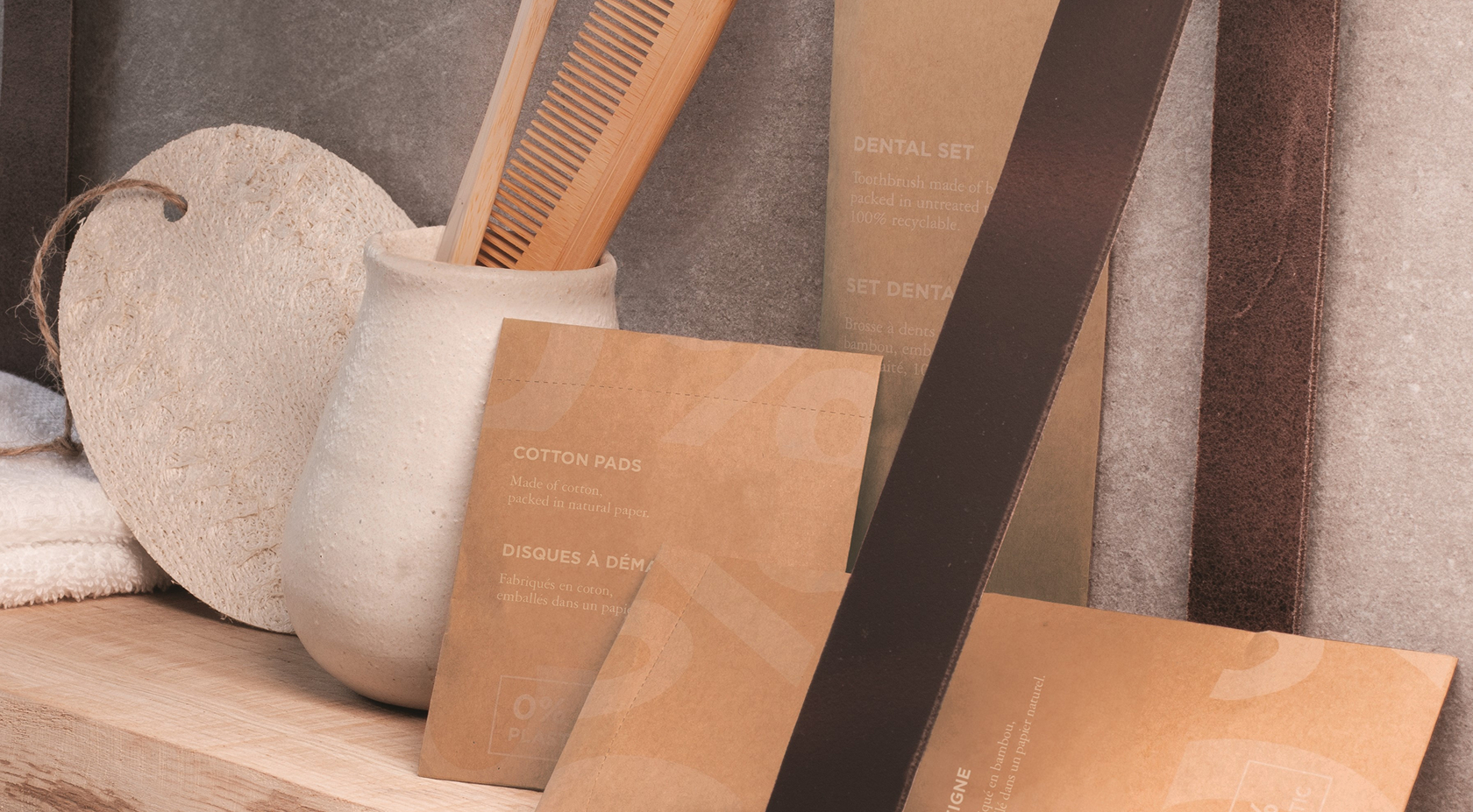Ein minimalistisches Regal, auf dem eine strukturierte Keramikvase, ein Holzkamm und umweltfreundliche Verpackungen für Zahnpflege- und Baumwollprodukte vor einem neutralen Hintergrund präsentiert werden.