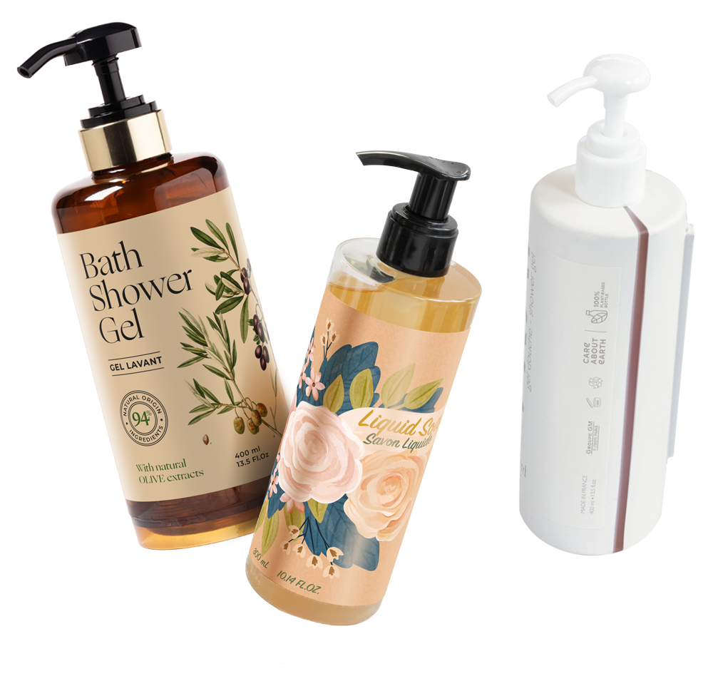 Três frascos de produtos para banho: um frasco castanho escuro com a etiqueta «Gel de Banho» com extratos de azeitona, um frasco com padrão floral com a etiqueta «Sabonete Líquido» e um frasco branco com bomba.