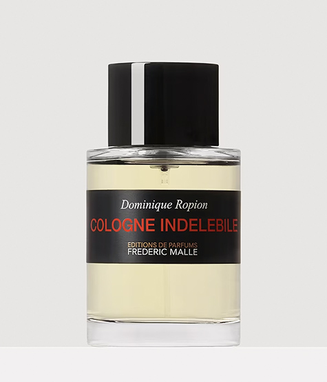 Eine durchsichtige Glasflasche mit schwarzem Verschluss, beschriftet mit „Cologne Indelible” von Dominique Ropion, die eine hellgelbe Flüssigkeit enthält. Das Etikett ist mit schwarzem und rotem Text versehen.