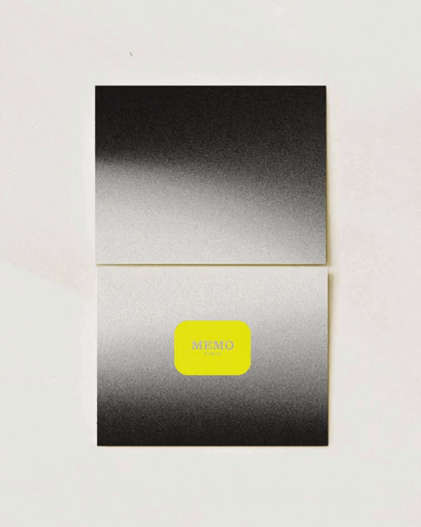 Un blocco note piegato con una copertina in bianco e nero sfumato e un'etichetta giallo brillante con la scritta "MEMO" al centro.