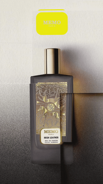 Eine schwarze Parfümflasche mit kunstvollen Goldverzierungen und der Aufschrift „MEMO IRISH LEATHER” vor einem Hintergrund mit Farbverlauf, gekrönt von einem leuchtend gelben Verschluss.