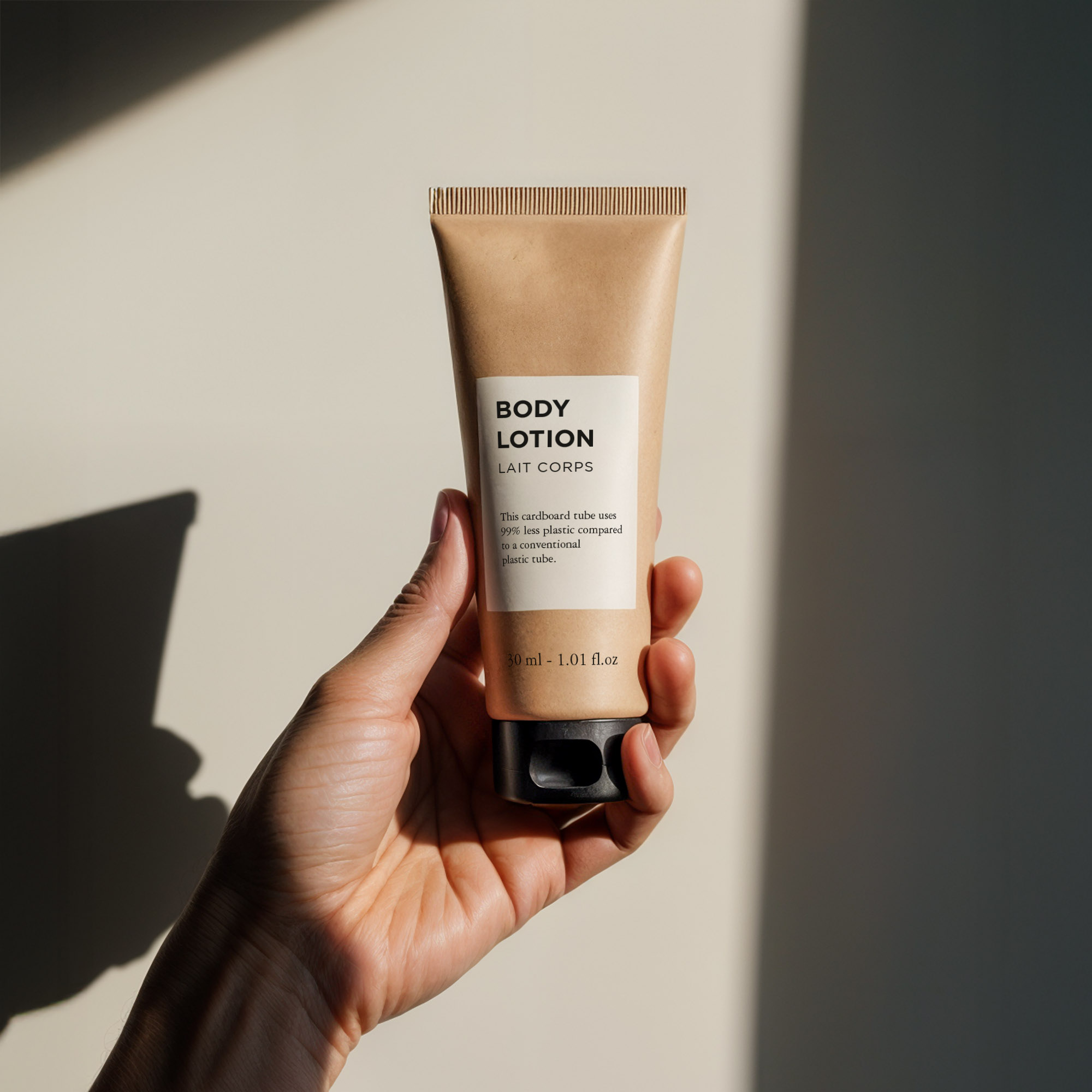 Eine Hand hält eine Tube Körperlotion mit minimalistischem Design, die ein beiges Etikett und schwarzen Text vor einem sanft beleuchteten Hintergrund aufweist.