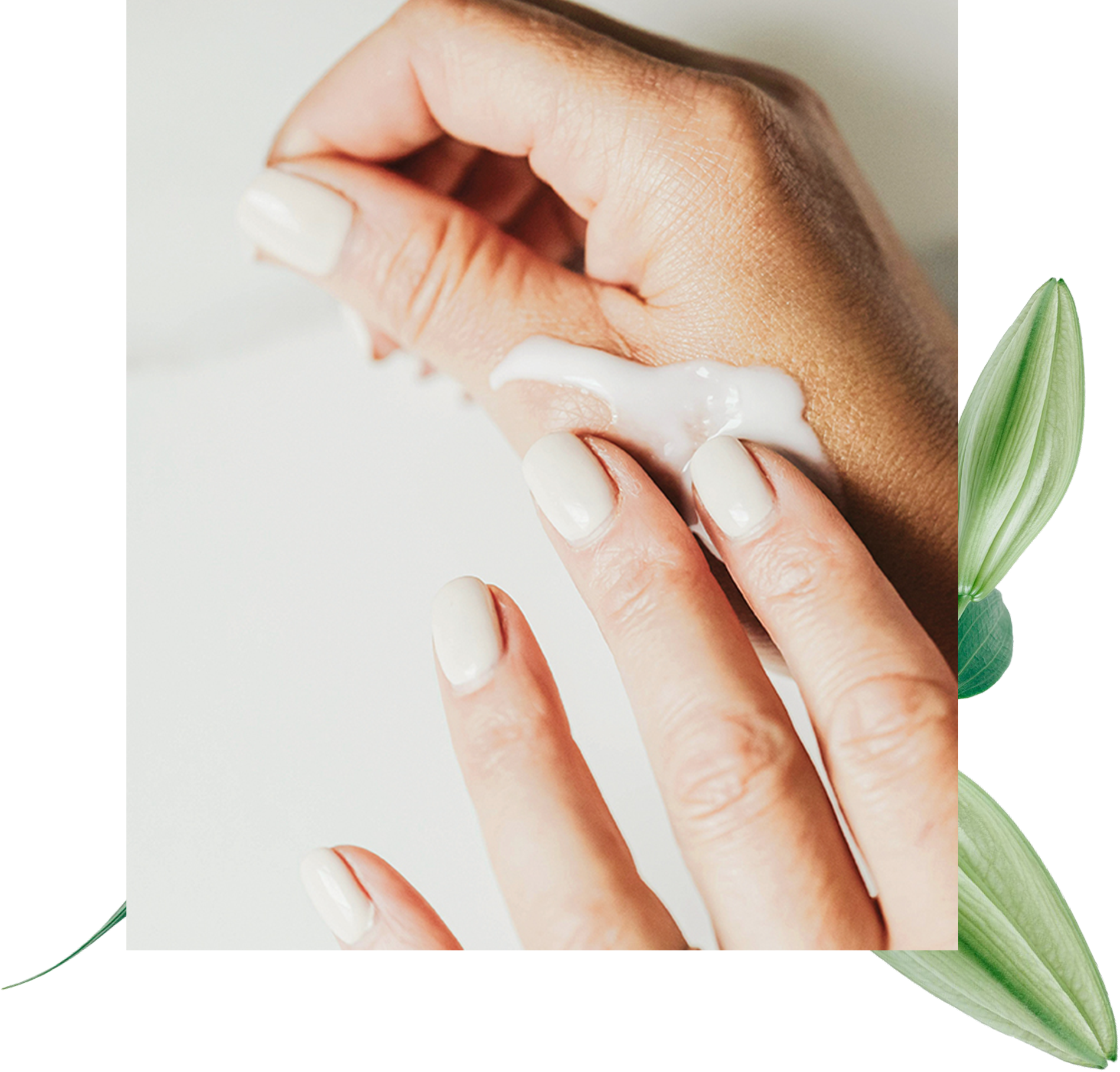 Nahaufnahme einer Hand, die Creme auf das Handgelenk aufträgt, mit hell lackierten Fingernägeln und einem minimalistischen Hintergrund mit grünen Blättern.