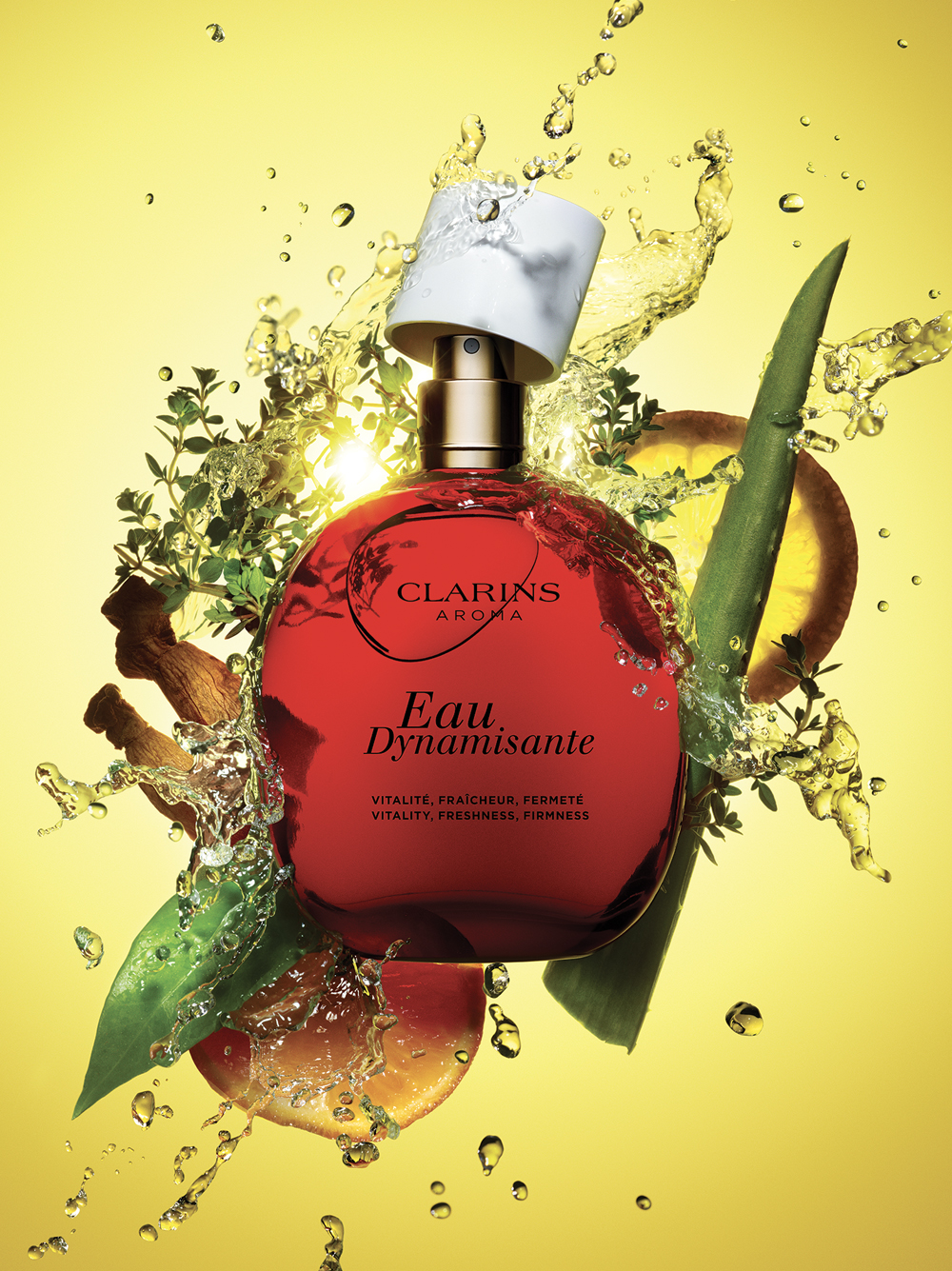 Eine rote Parfümflasche mit der Aufschrift „Eau Dynamisante” von Clarins umgeben von Wasserspritzern, Kräutern und Früchten vor einem leuchtend gelben Hintergrund.