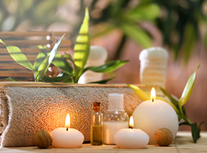 Un ambiente spa sereno caratterizzato da candele, oli essenziali e piante illuminate da luci soffuse, che creano un'atmosfera rilassante.