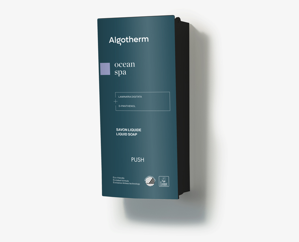 一款壁掛式液體肥皂分配器,標示「Algotherm Spa」字樣,採用深藍色設計搭配極簡文字。分配器上設有「按壓」操作指示標記。