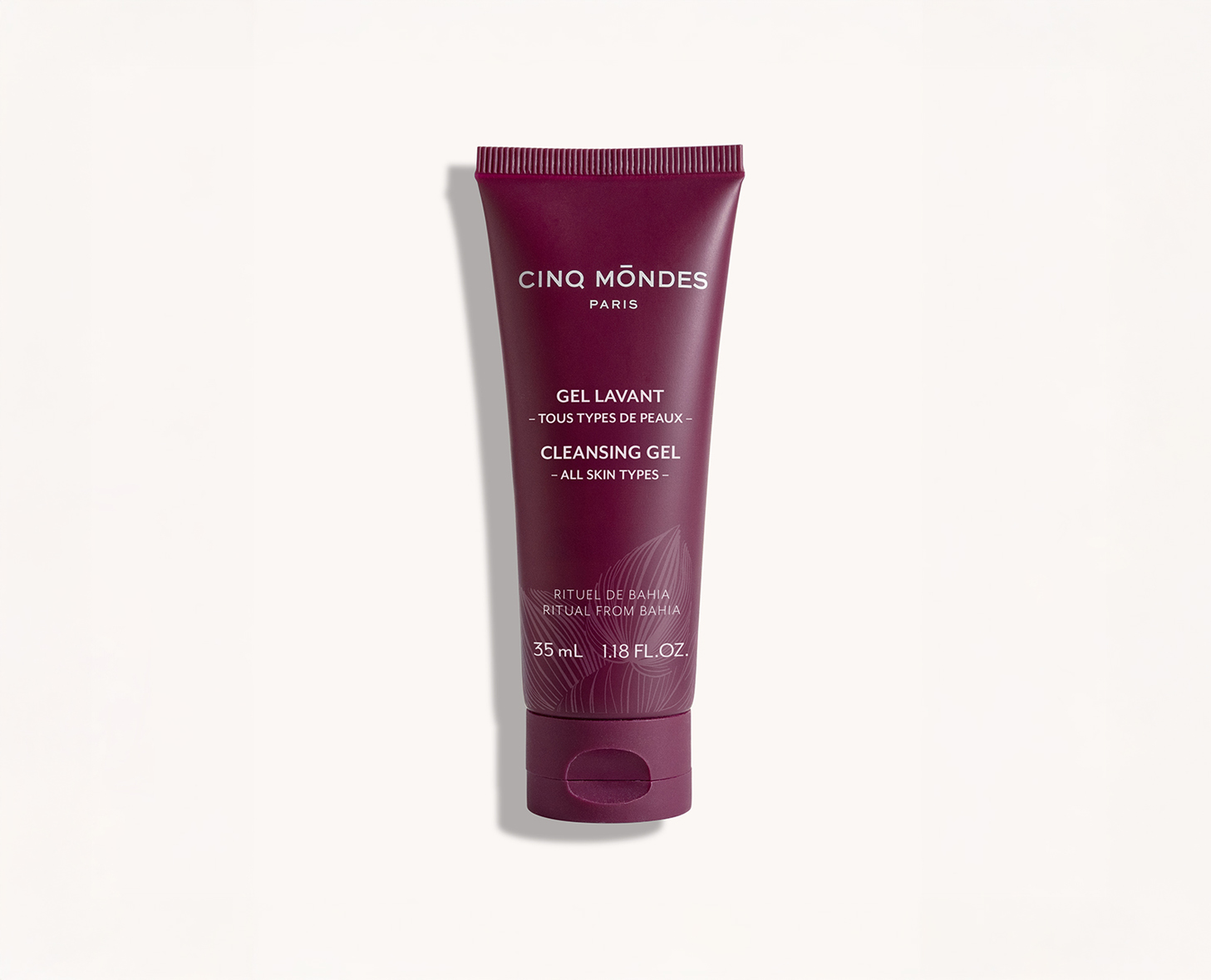 Uma bisnaga de Gel Cinq Mondes para todos os tipos de pele, com um design em cor vinho e rótulo com detalhes do produto em inglês e francês.