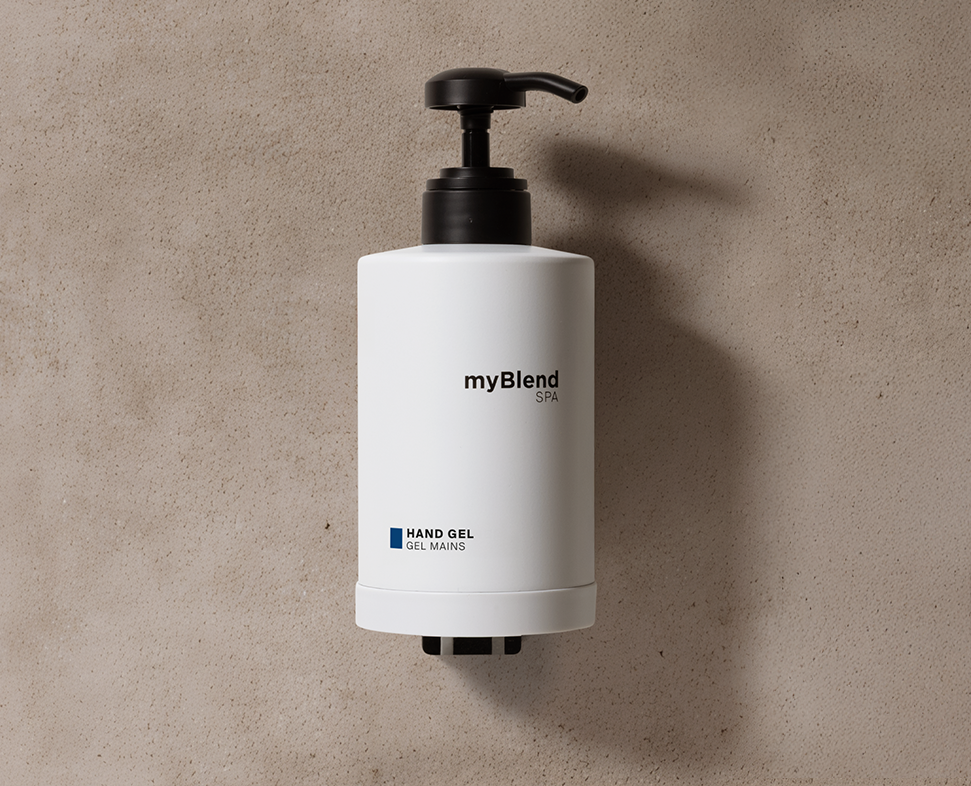 Ένα λευκό μπουκάλι με αντλία του gel myBlend Spa με μινιμαλιστικό σχεδιασμό, τοποθετημένο πάνω σε ένα μπεζ φόντο με υφή.
