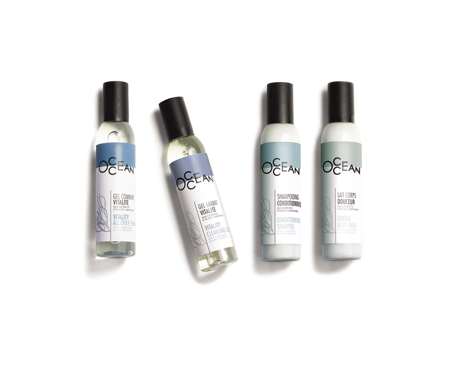Quattro flaconi di prodotti per la cura dei capelli e del corpo allineati, con etichette blu e verdi con il marchio "OCEAN". I flaconi contengono un gel, una lozione, uno shampoo e un balsamo.