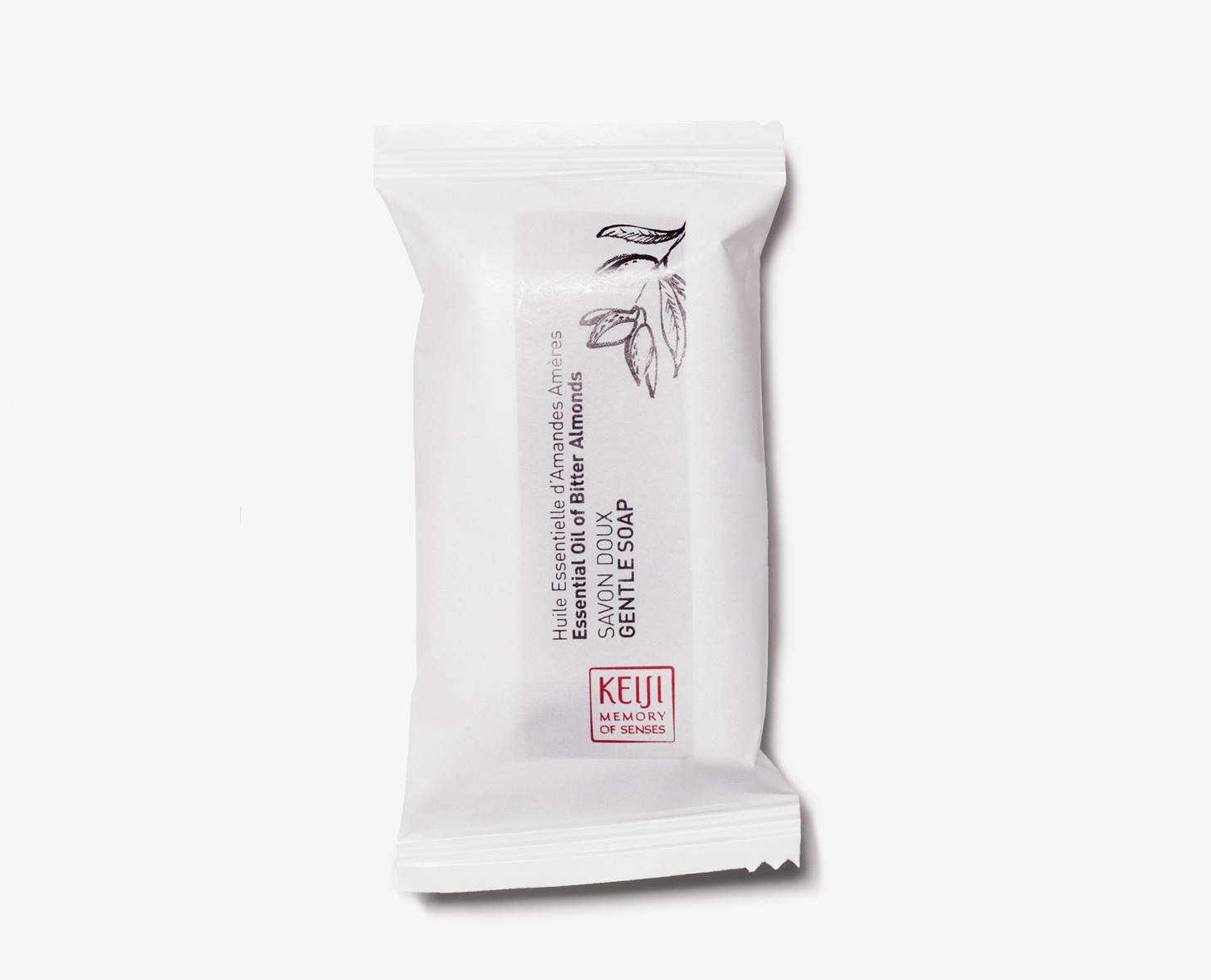 Ein weißes Stück Seife, verpackt in einer minimalistischen Verpackung mit Text in mehreren Sprachen, der es als milde Seife mit Mandelöl beschreibt.