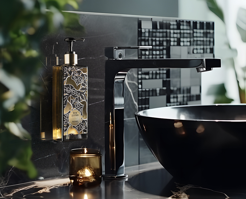 Ein moderner schwarzer Wasserhahn und ein stilvoller Seifenspender stehen vor einem eleganten Hintergrund aus dunklem Marmor, dazu eine minimalistische schwarze Schale und eine Kerze in der Nähe, die dem Badezimmer einen Hauch von Eleganz verleihen.
