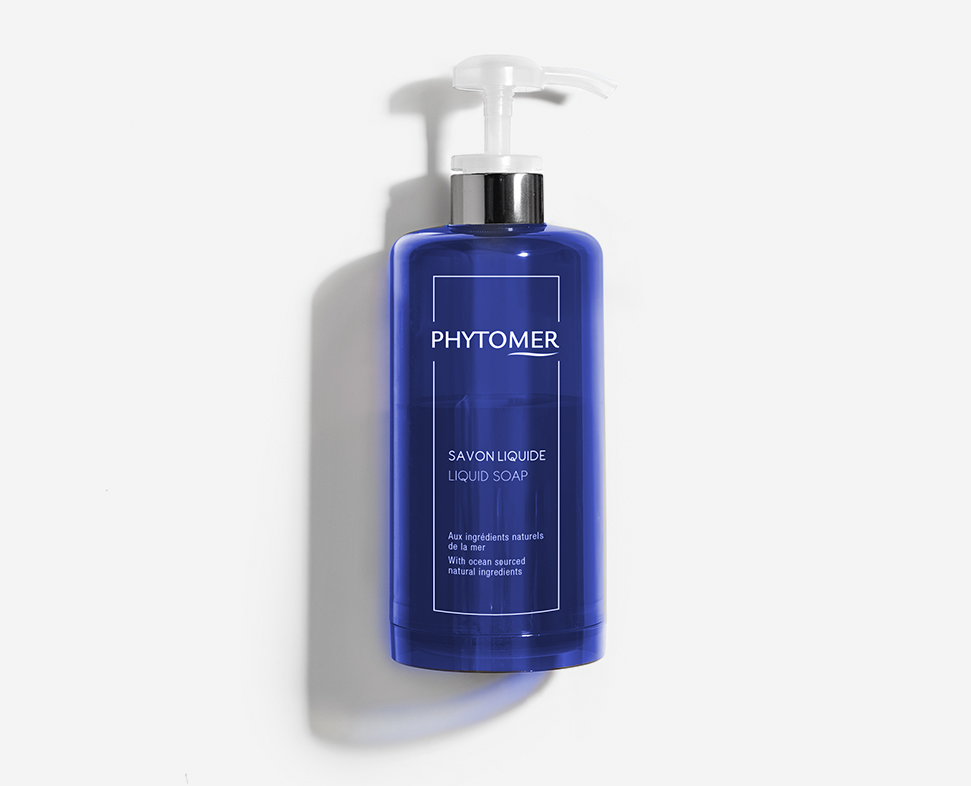 Een blauwe fles Phytomer zeep met een pompdispenser, voorzien van een minimalistisch etiket met de tekst "Savon Liquide" en "Liquid Soap".