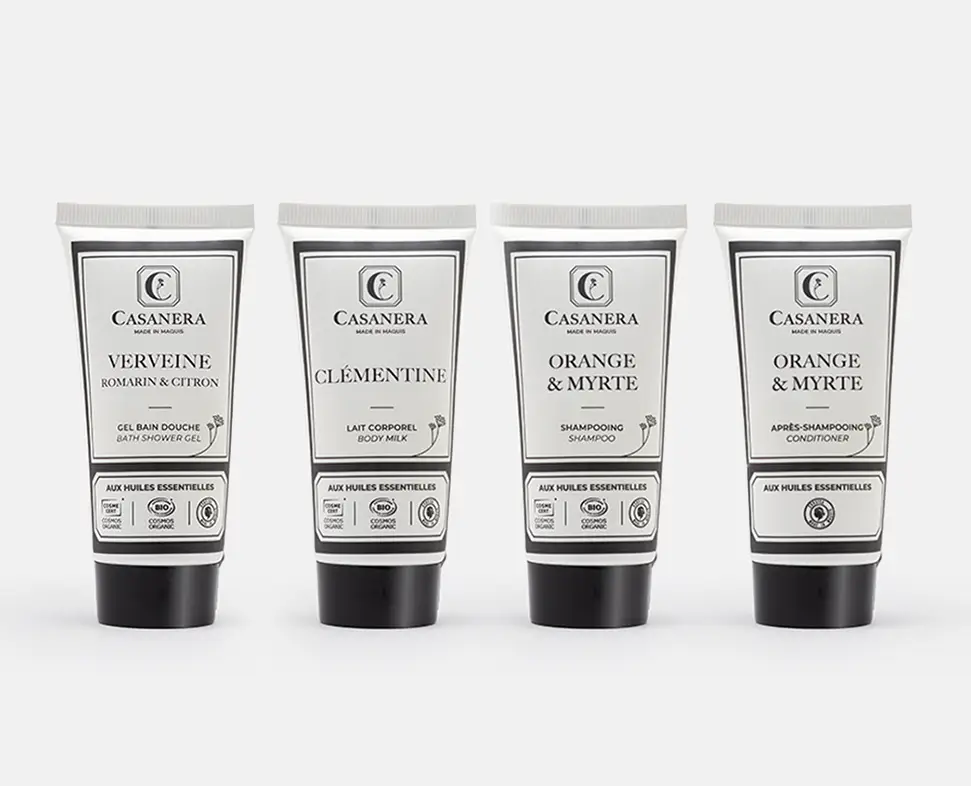 Vier Tuben mit Casanera , darunter ein Duschgel, eine Körperlotion, ein Shampoo und eine Haarspülung, alle in eleganter schwarz-weißer Verpackung mit Produktnamen und Beschreibungen.