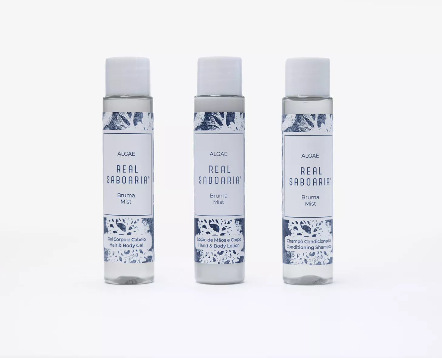 Tre piccole bottiglie di prodotti per la cura della pelle con l'etichetta "Real Sabooaria" dal design leggero e fresco. I prodotti includono "Bruma Mist", "Gel Corporal Calib" e "Champô Condicionador".