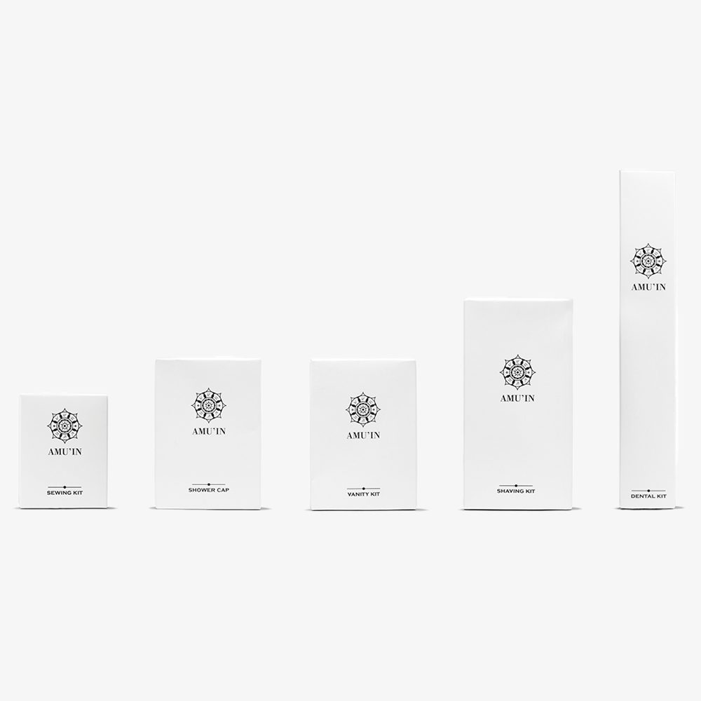 Un set di cinque scatole bianche dal design minimalista, ciascuna contrassegnata dal marchio "AMUT'IN" e indicante diversi prodotti come "Kit da barba", "Kit da toeletta" e "Cuffia da doccia". Le scatole sono disposte in ordine crescente di grandezza.