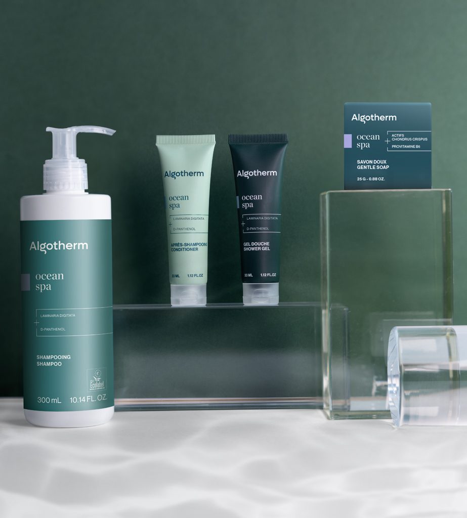 產品展示以柔和的綠色背景為襯,Algotherm Spa護膚系列商品,包含一瓶洗髮精與兩支凝膠。