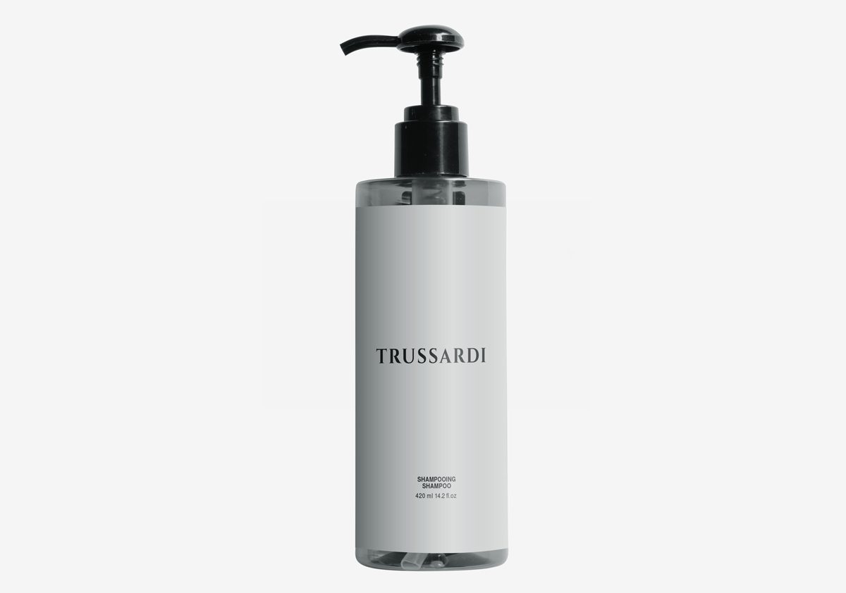 Eine durchsichtige Shampooflasche mit schwarzem Pumpaufsatz, minimalistischem Design und der AufschriftTRUSSARDI” in fetten Buchstaben.