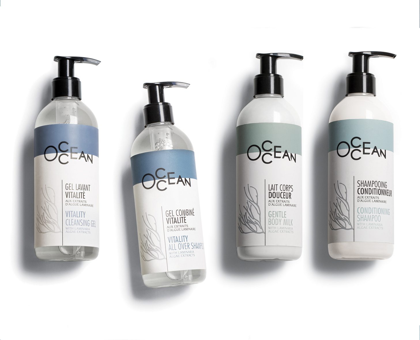 Quattro flaconi di prodotti per la cura dei capelli e del corpo con l'etichetta "OCEAN", comprendenti un gel detergente, uno shampoo per tutto il corpo, un latte corpo e uno shampoo balsamo. Ogni flacone è dotato di un erogatore a pompa e presenta un design moderno e minimalista.