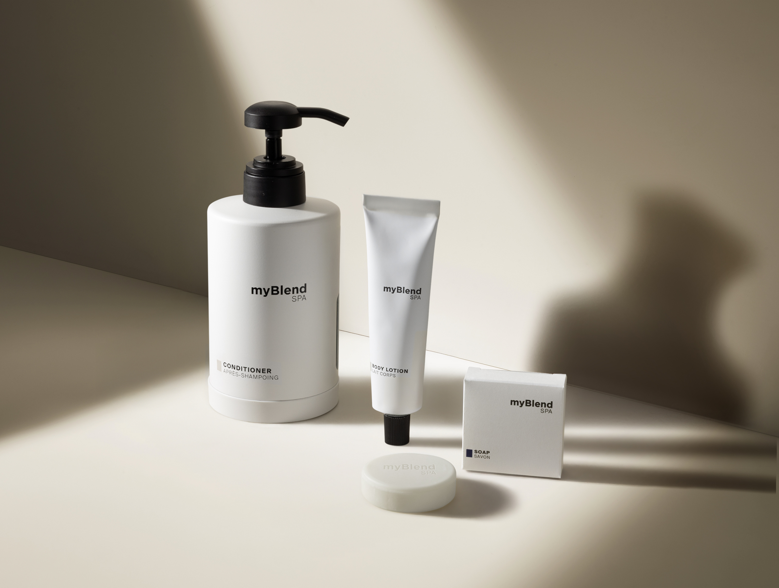 Bianco minimalista myBlend Spa prodotti per la cura della pelle, tra cui balsamo, lozione per il corpo e sapone, esposti su uno sfondo neutro con ombre delicate.
