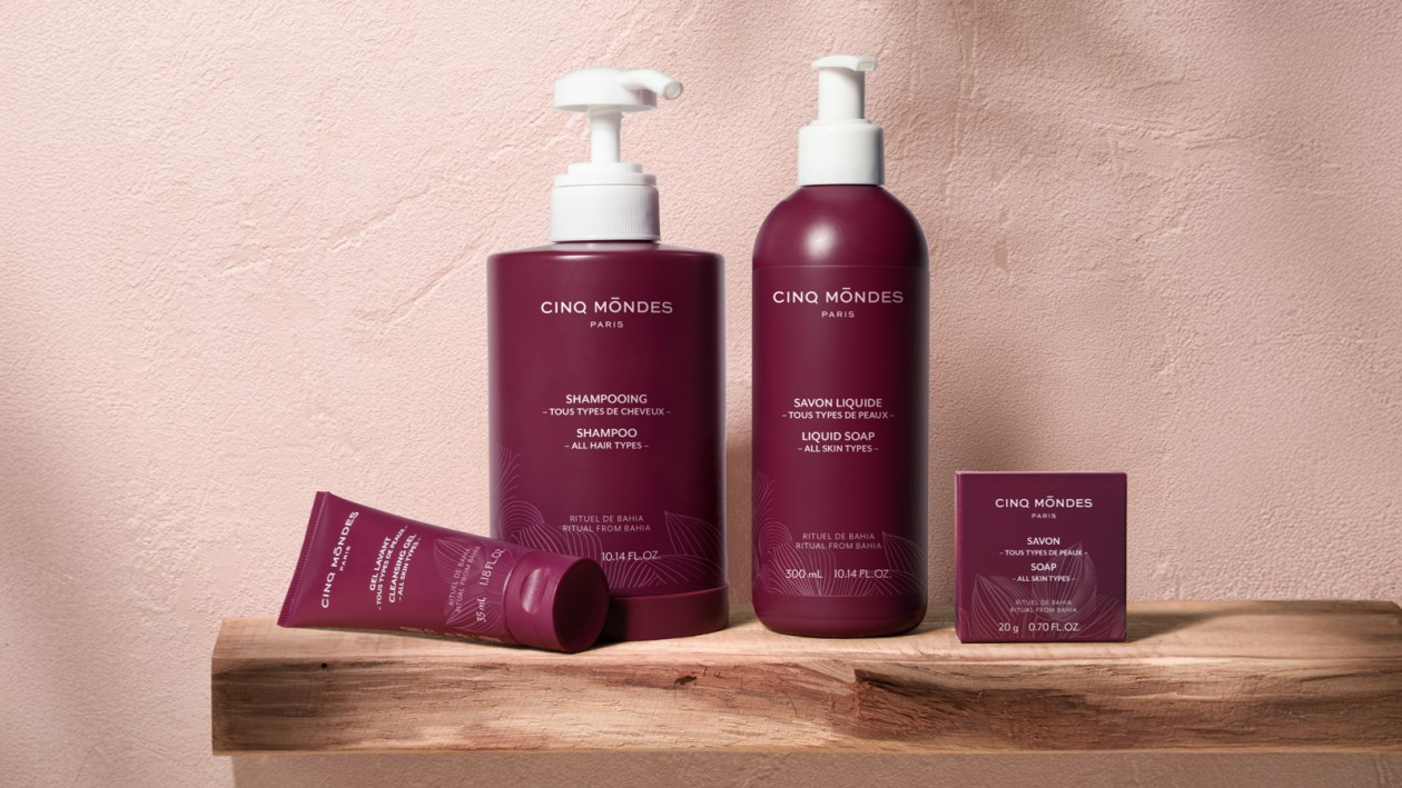 Cinq Mondes Hautpflegeprodukte von Cinq Mondes (Shampoo, Flüssigseife, Reinigungsgel und Seifenstück) auf einem Holzregal