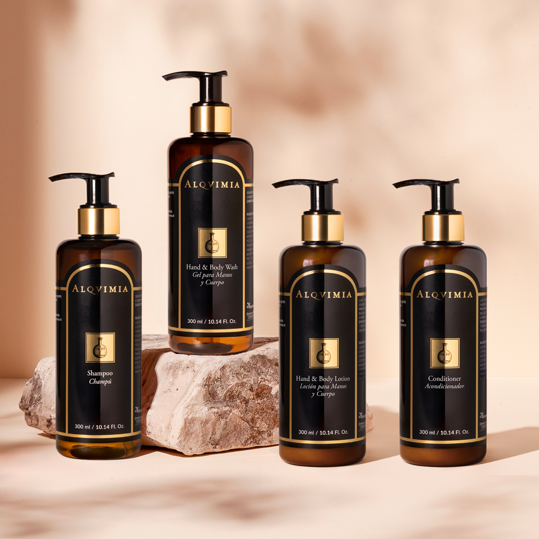 Alqvimia Spa-Serie mit Shampoo, Hand- und Duschgel, Lotion und Haarspülung in Pumpflaschen, präsentiert auf Naturstein