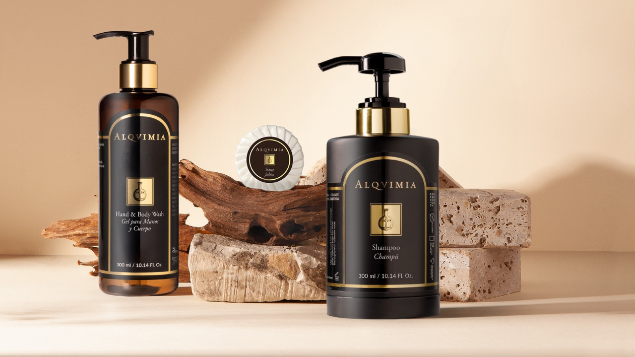 Alqvimia Spa-Produkte wie Shampoo, Hand- und Duschgel sowie Seife, präsentiert in einem Dekor aus Naturstein und Holz