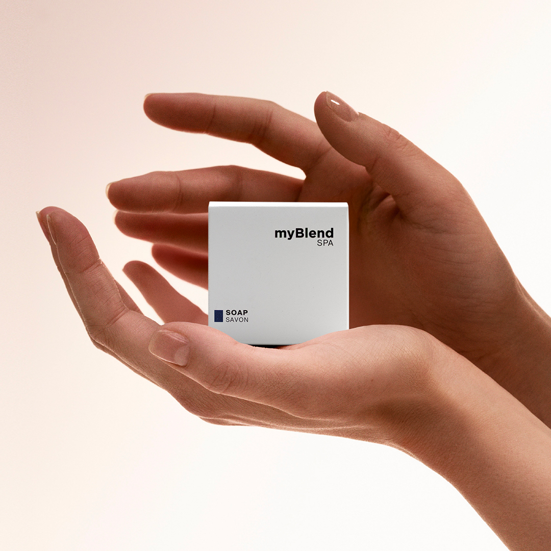Hands holding a myBlend Spa soap box against a clean, neutral background