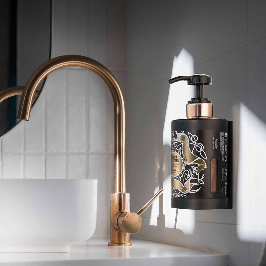 Memo Paris Irish Leather Wandmontierter Handseifenspender neben einem goldenen Wasserhahn