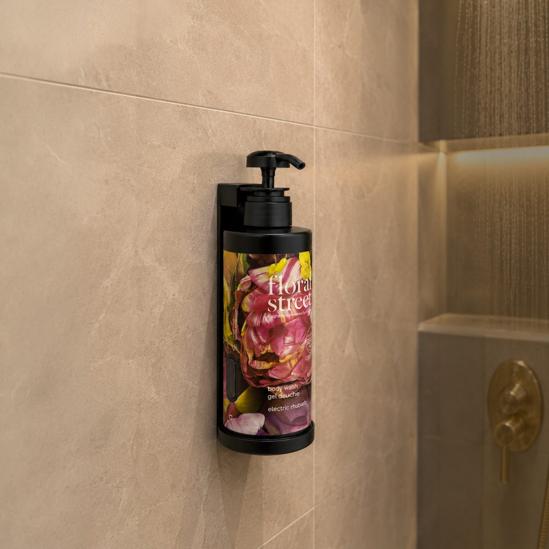 Floral Street frascos de recarga de gel de banho Electric Rhubarb frascos num chuveiro minimalista com acessórios dourados e uma prateleira embutida.