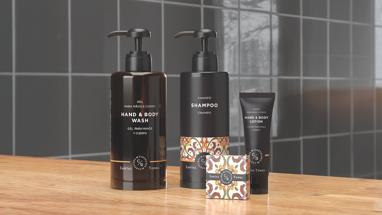 Santal Tonka hospitality collection featuring hand & body wash, shampoo, body lotion, and soap displayed on a wooden countertop in a modern bathroom setting.