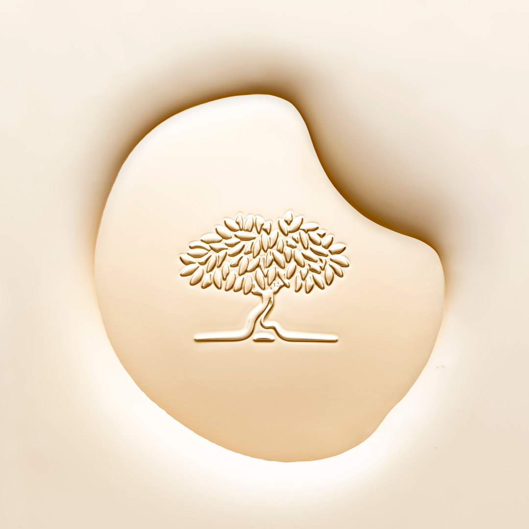 Crème de soin de luxe ornée d'un logo en relief représentant un arbre, symbolisant des cosmétiques naturels haut de gamme et des soins de la peau.
